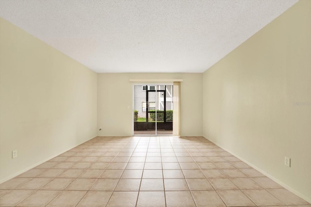 unfurnished room with a textured ceiling and light tile patterned floors