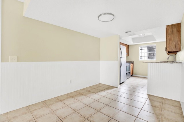 interior space featuring light tile patterned floors and a tray ceiling