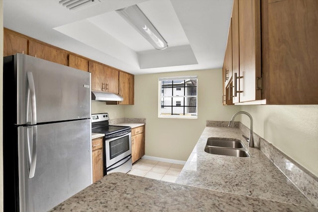 kitchen with sink, a raised ceiling, appliances with stainless steel finishes, and light tile patterned flooring