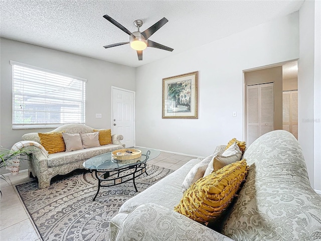 tiled living room featuring a textured ceiling and ceiling fan