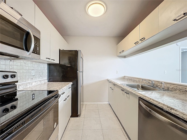 kitchen featuring light tile patterned floors, appliances with stainless steel finishes, sink, and decorative backsplash