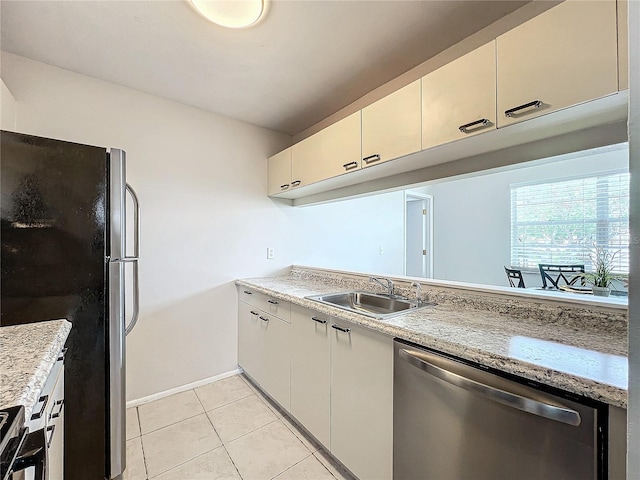 kitchen featuring light tile patterned floors, appliances with stainless steel finishes, sink, and light stone counters