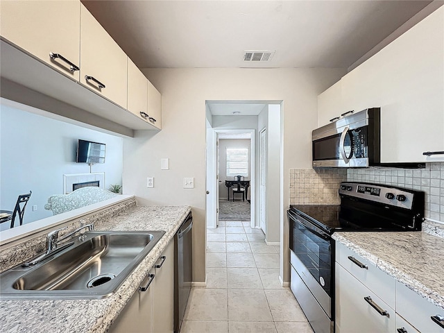 kitchen featuring visible vents, appliances with stainless steel finishes, decorative backsplash, and a sink