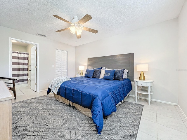 tiled bedroom with ceiling fan, a closet, ensuite bathroom, and a textured ceiling