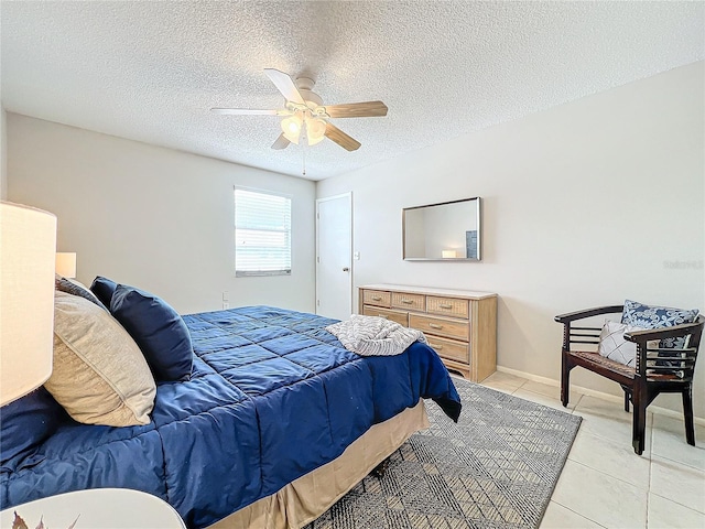 bedroom with ceiling fan, a textured ceiling, and light tile patterned floors