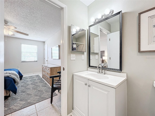 bathroom with ceiling fan, tile patterned floors, a textured ceiling, and vanity