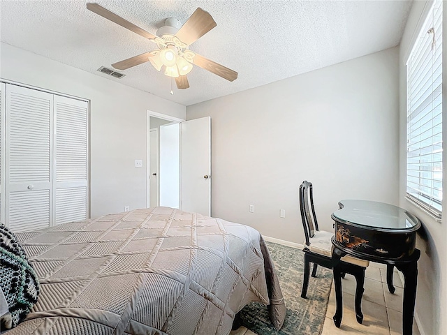 bedroom with a textured ceiling, a closet, and ceiling fan