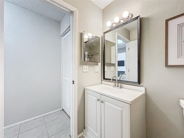 bathroom featuring tile patterned flooring, vanity, and baseboards