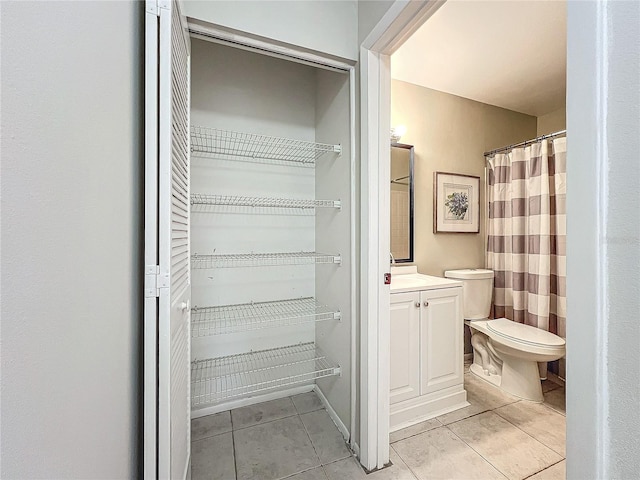 bathroom with tile patterned flooring, toilet, and vanity