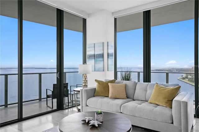 living room featuring a water view, expansive windows, and plenty of natural light