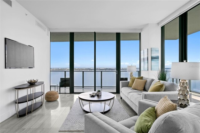 living room with floor to ceiling windows and light tile patterned flooring