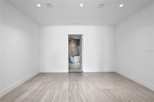 empty room with visible vents, baseboards, wood finished floors, and recessed lighting