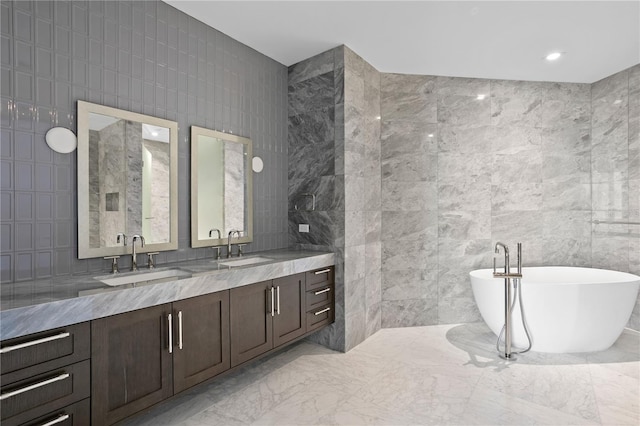 bathroom with vanity, tile walls, and a washtub