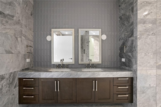 bathroom featuring vanity and tile walls