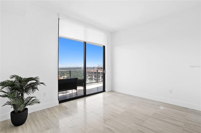 empty room featuring baseboards and floor to ceiling windows