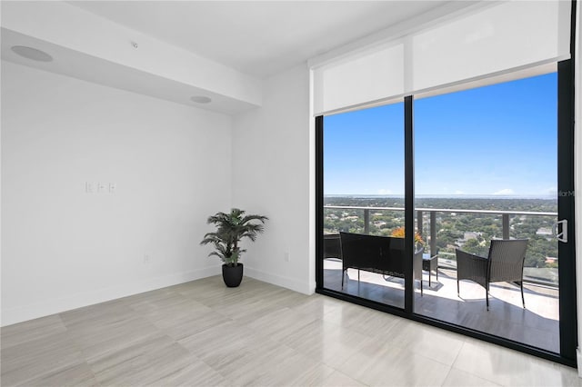 spare room with expansive windows and baseboards