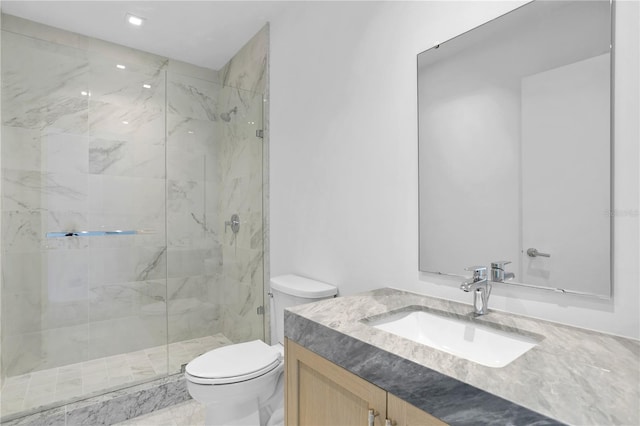 full bathroom featuring toilet, a marble finish shower, and vanity