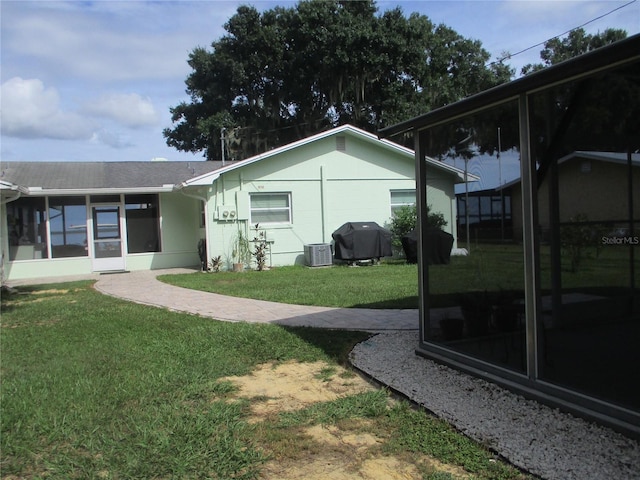 view of yard featuring a sunroom and cooling unit