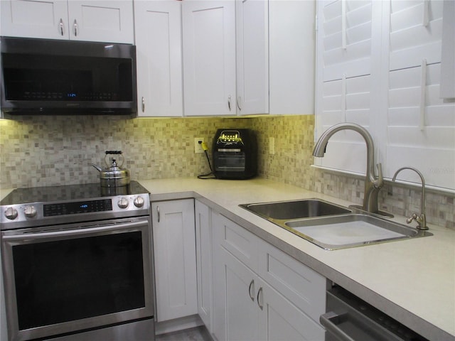 kitchen featuring white cabinetry, appliances with stainless steel finishes, and backsplash