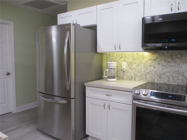 kitchen with backsplash, stainless steel appliances, light hardwood / wood-style flooring, and white cabinets