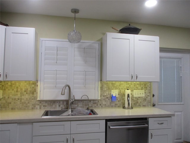 kitchen with sink, decorative light fixtures, stainless steel dishwasher, tasteful backsplash, and white cabinetry