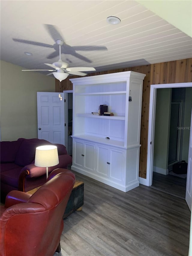 living room featuring ceiling fan, wood walls, and wood-type flooring