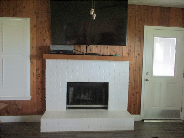 interior details featuring hardwood / wood-style floors, wooden walls, and a fireplace