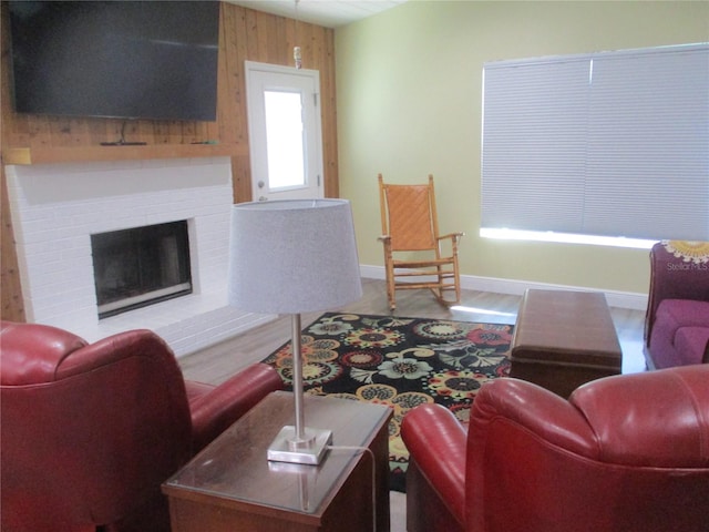 living room featuring a fireplace, wooden walls, and wood-type flooring