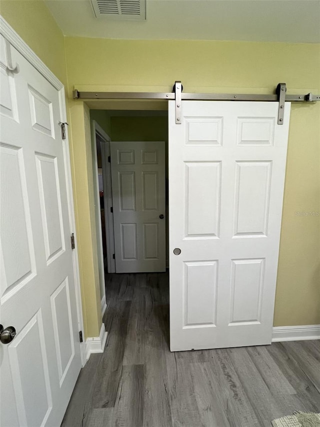 hall featuring hardwood / wood-style floors and a barn door