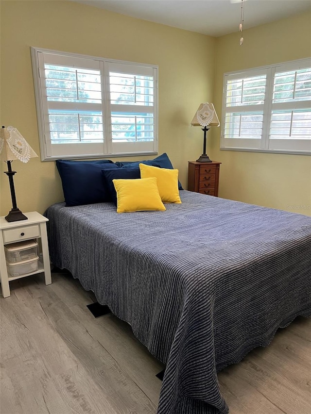 bedroom featuring light hardwood / wood-style flooring and multiple windows