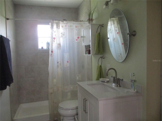 bathroom featuring curtained shower, vanity, and toilet