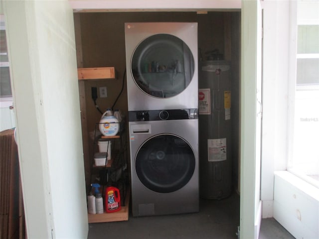 clothes washing area with stacked washer / drying machine and water heater