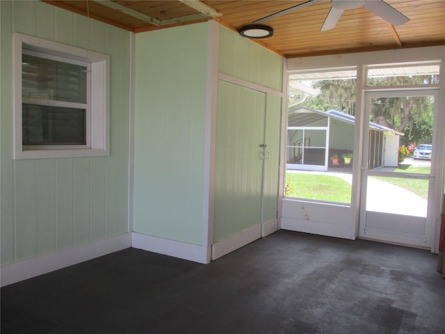 unfurnished sunroom with wood ceiling and ceiling fan