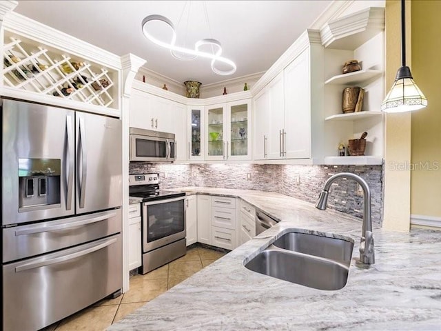 kitchen featuring light tile patterned floors, stainless steel appliances, sink, decorative backsplash, and white cabinets