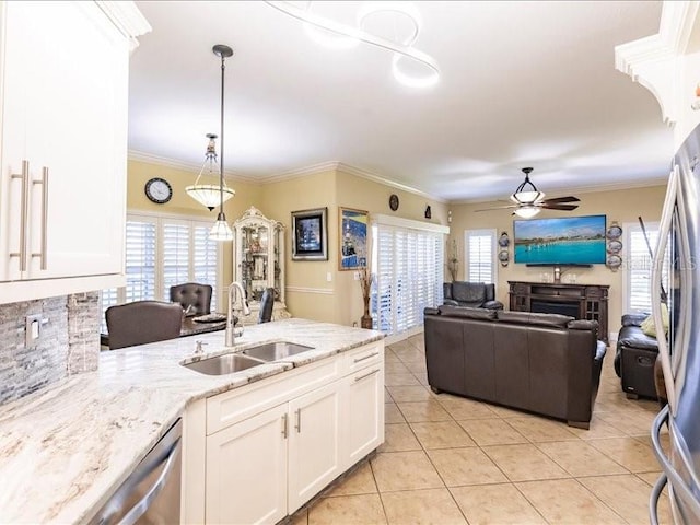 kitchen featuring a fireplace, white cabinetry, decorative light fixtures, sink, and ceiling fan