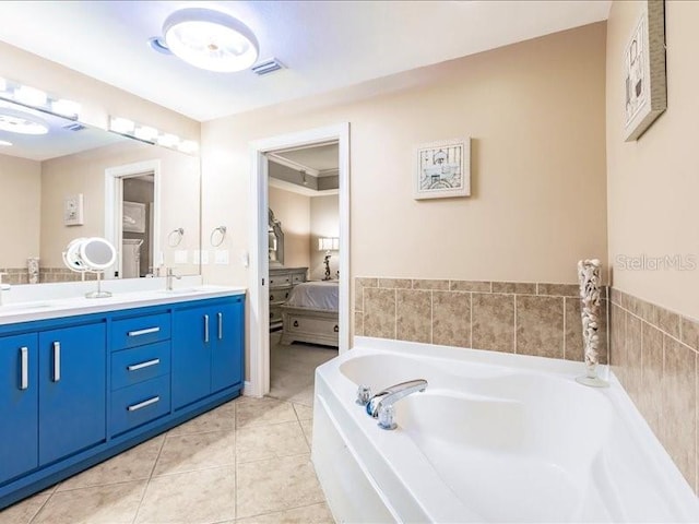 bathroom featuring tile patterned flooring, a washtub, and vanity