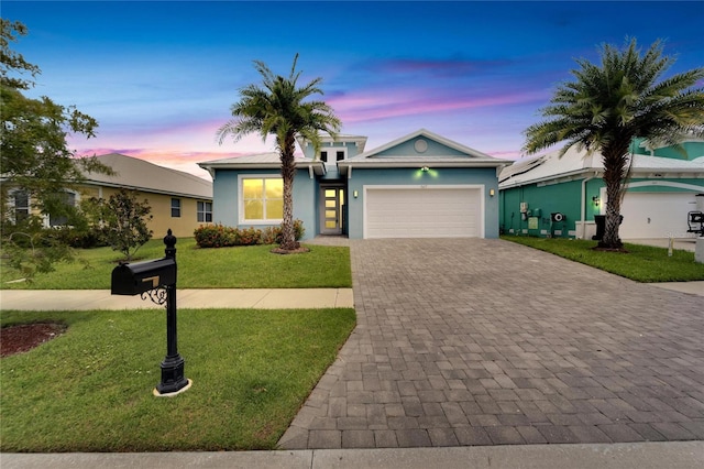 view of front of property with decorative driveway, a yard, an attached garage, and stucco siding