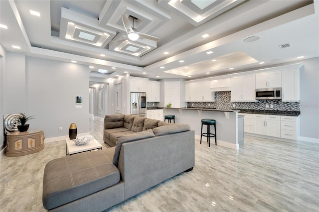 living area featuring baseboards, coffered ceiling, a raised ceiling, ceiling fan, and recessed lighting