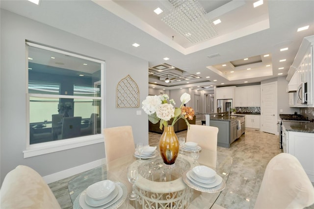 dining room featuring baseboards, a raised ceiling, and recessed lighting