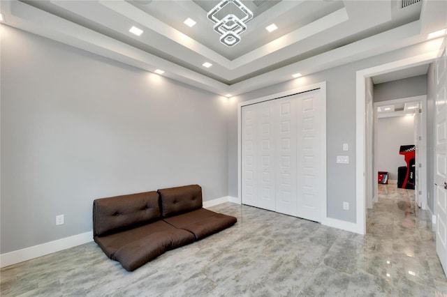 sitting room with baseboards and a tray ceiling