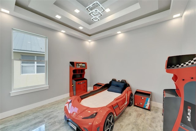 bedroom with a tray ceiling and baseboards