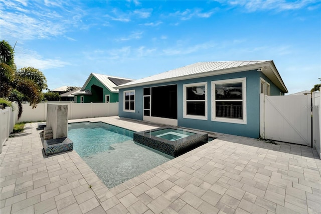 back of house with a fenced backyard, metal roof, a gate, a patio area, and stucco siding