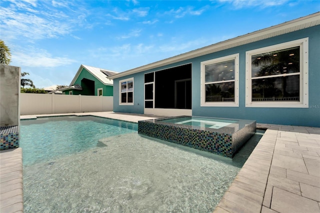 view of swimming pool featuring a patio area, a pool with connected hot tub, and fence