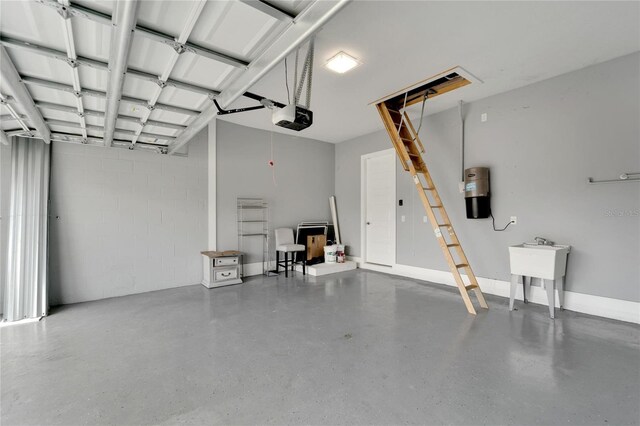 garage with a garage door opener and concrete block wall