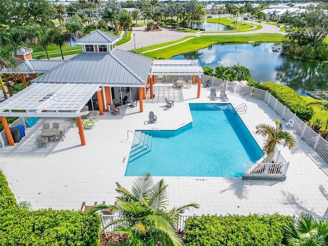 community pool with a patio area, a water view, fence, and a pergola