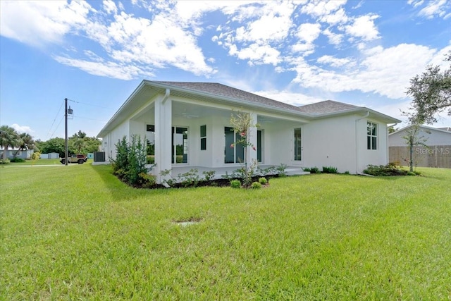 view of front of house with a front lawn, fence, cooling unit, and stucco siding