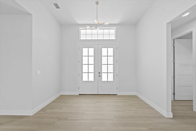 foyer featuring a chandelier, visible vents, baseboards, french doors, and light wood-type flooring