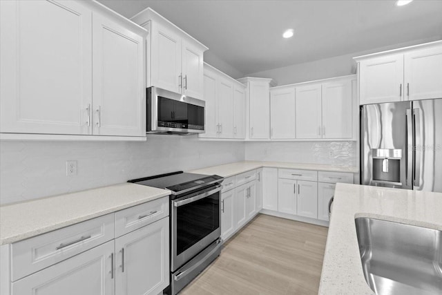 kitchen featuring light wood-style flooring, appliances with stainless steel finishes, white cabinets, and recessed lighting