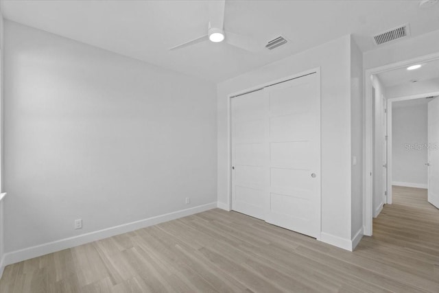 unfurnished bedroom with light wood-style flooring, visible vents, and baseboards