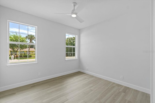 empty room with light wood-style floors, baseboards, and a ceiling fan